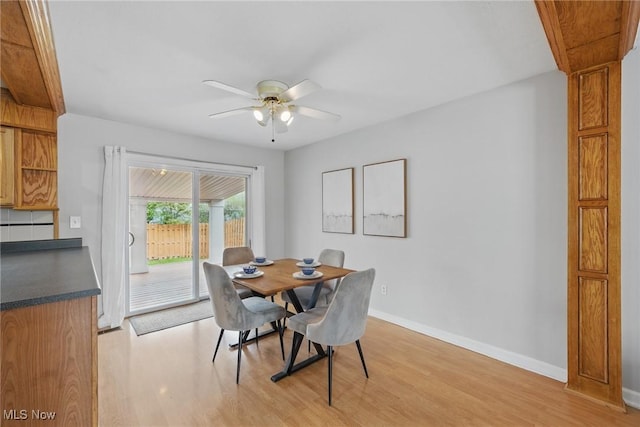dining room featuring baseboards, a ceiling fan, and light wood finished floors