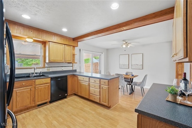 kitchen with a peninsula, beam ceiling, light wood-style floors, a sink, and black appliances
