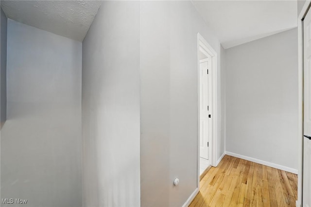 hallway with baseboards and light wood-style floors