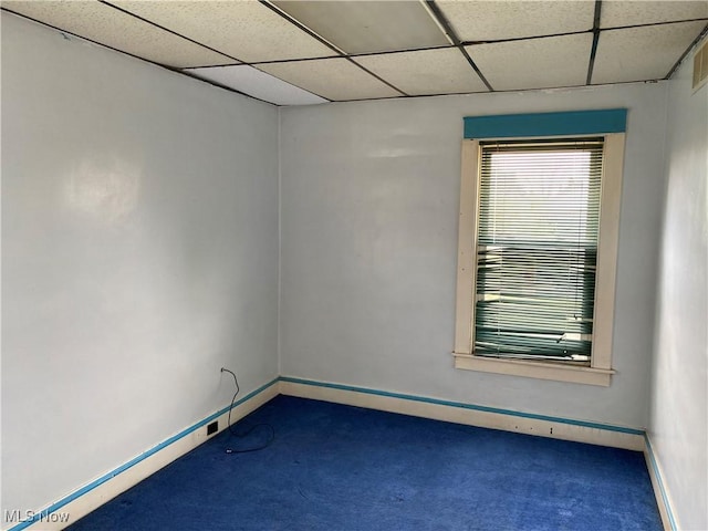 unfurnished room featuring baseboards, carpet flooring, and a paneled ceiling