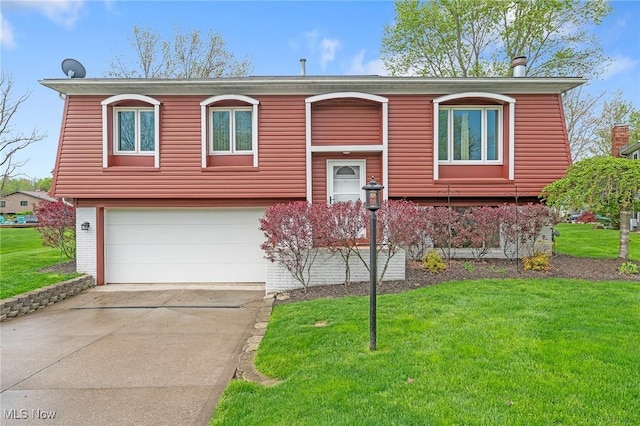 split foyer home featuring a garage, driveway, and a front lawn