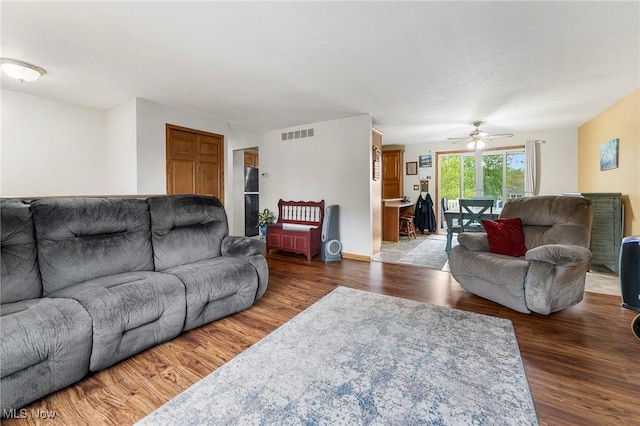 living room featuring visible vents, a ceiling fan, and wood finished floors