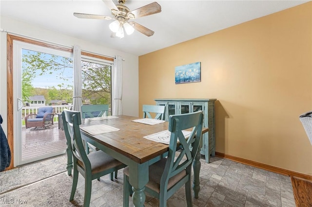 dining room featuring a ceiling fan, baseboards, and stone finish flooring