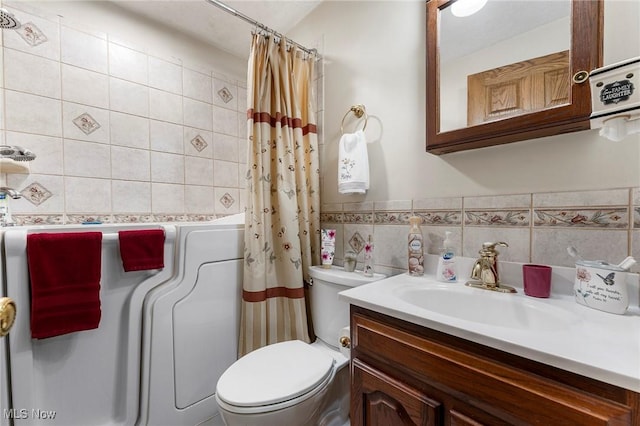 bathroom featuring vanity, toilet, and tile walls