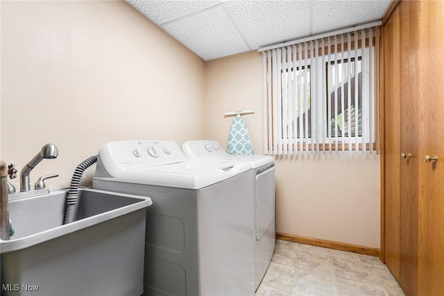 laundry room featuring a sink, baseboards, laundry area, and washer and clothes dryer