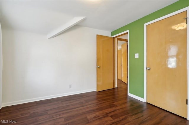 interior space featuring baseboards and dark wood-type flooring