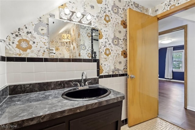 bathroom with vanity, tile walls, and wallpapered walls