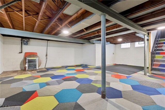 basement featuring stairway and carpet