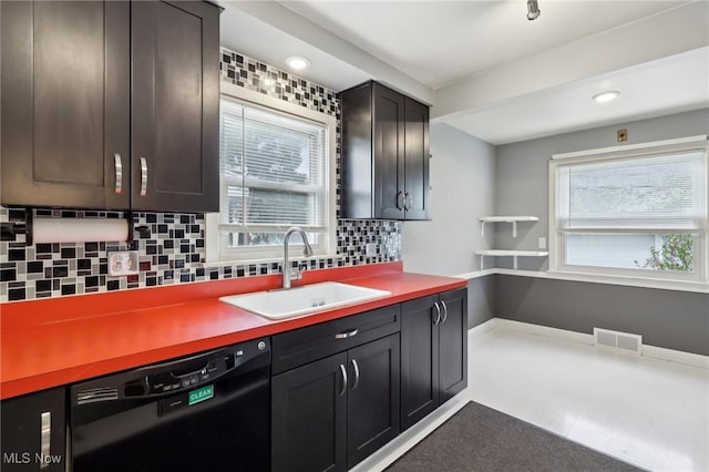 kitchen with visible vents, a sink, black dishwasher, and tasteful backsplash
