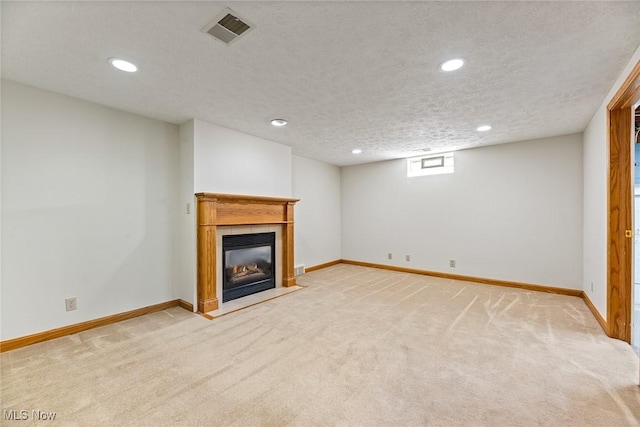 basement featuring visible vents, recessed lighting, baseboards, and light carpet