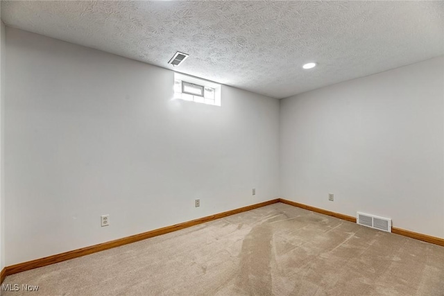 basement featuring baseboards, carpet, and visible vents