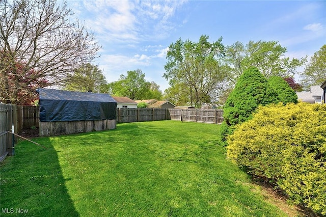 view of yard featuring a fenced backyard and an outbuilding