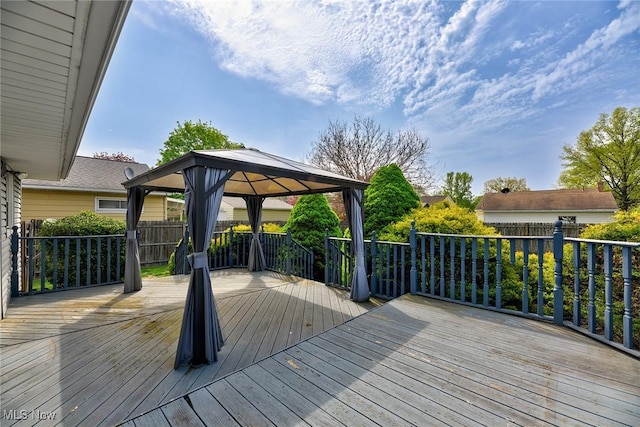 wooden terrace featuring fence and a gazebo