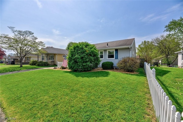 ranch-style house featuring fence and a front lawn