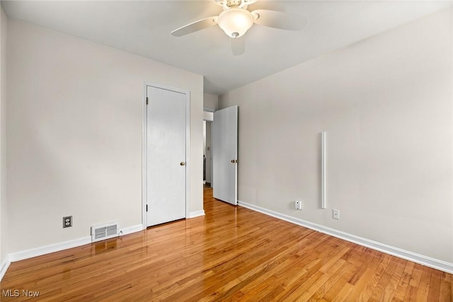 unfurnished bedroom featuring baseboards, a ceiling fan, light wood-type flooring, and visible vents