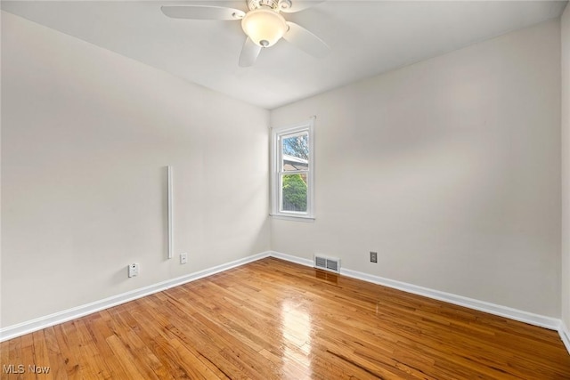 unfurnished room featuring a ceiling fan, baseboards, visible vents, and light wood-style floors