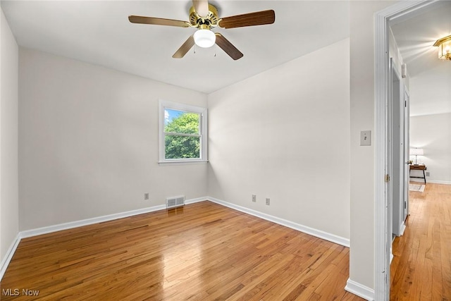 unfurnished room with visible vents, light wood finished floors, and baseboards