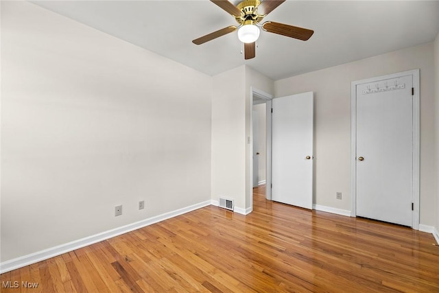 unfurnished bedroom featuring baseboards, a ceiling fan, light wood finished floors, and visible vents