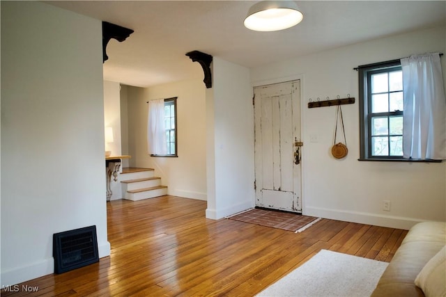 entrance foyer featuring baseboards, plenty of natural light, stairs, and hardwood / wood-style floors