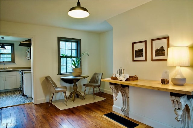 dining room with dark wood-style flooring and baseboards
