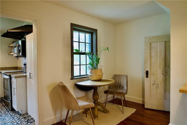 dining space featuring baseboards and dark wood finished floors