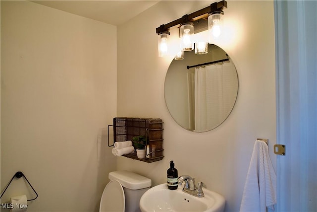 full bath featuring toilet and a sink