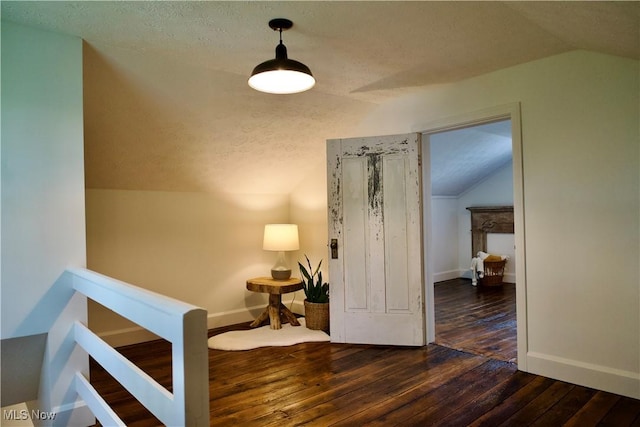 sitting room featuring baseboards, hardwood / wood-style floors, and lofted ceiling