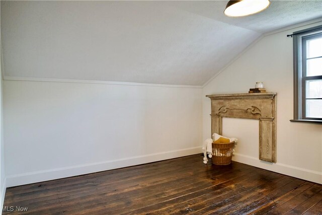 bonus room featuring baseboards, dark wood-type flooring, and lofted ceiling