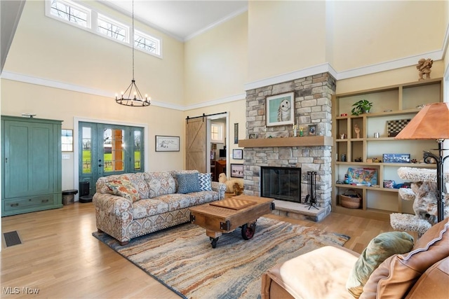 46748 New London Eastern Rd, New London, OH 44851 - living room featuring visible vents, a barn door, wood finished floors, and a towering ceiling