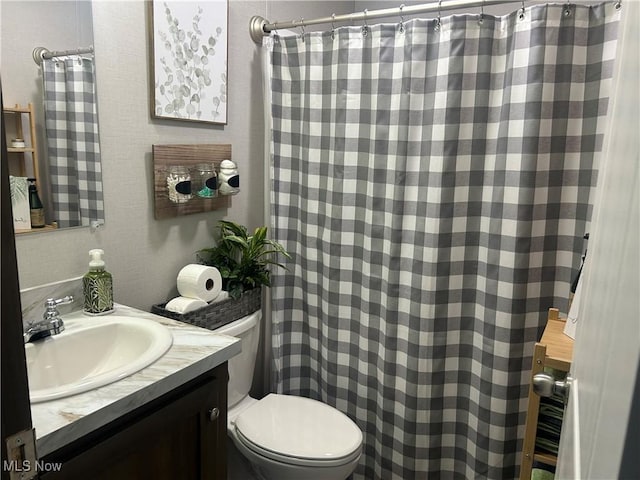 bathroom featuring toilet, curtained shower, and vanity