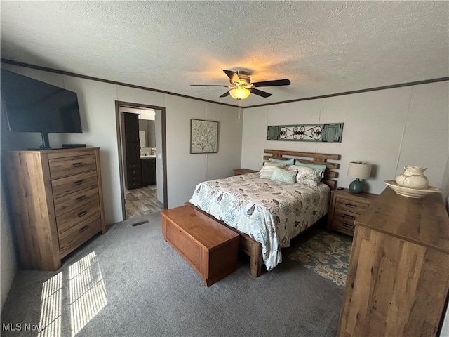 bedroom featuring crown molding, ensuite bath, carpet floors, a textured ceiling, and a ceiling fan
