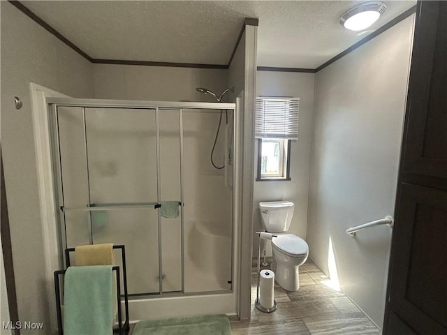 bathroom with crown molding, a textured ceiling, and a stall shower