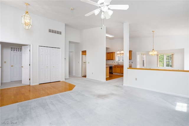 11235 Frederick Ln, Twinsburg, OH 44087 - unfurnished living room with visible vents, baseboards, ceiling fan, light colored carpet, and a sink