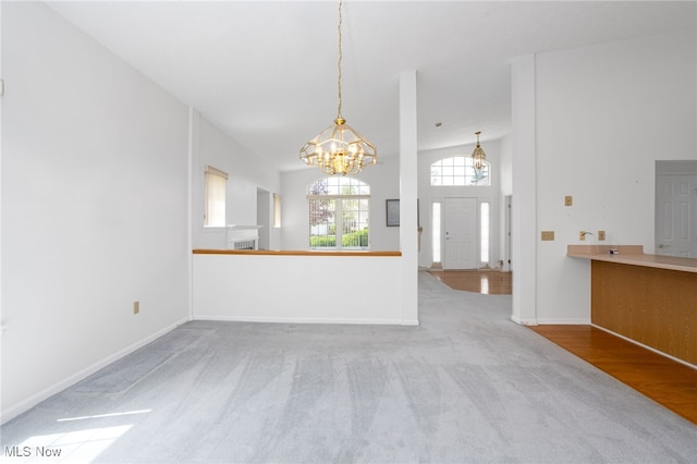 11235 Frederick Ln, Twinsburg, OH 44087 - unfurnished living room with carpet floors, baseboards, and a chandelier
