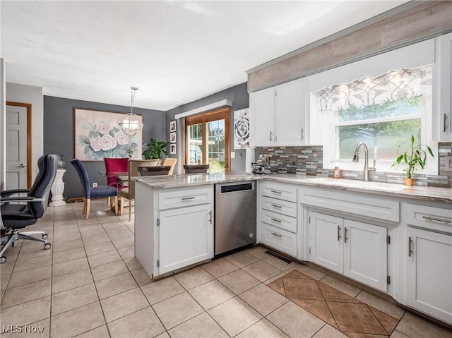 kitchen with stainless steel dishwasher, a peninsula, white cabinets, and tasteful backsplash