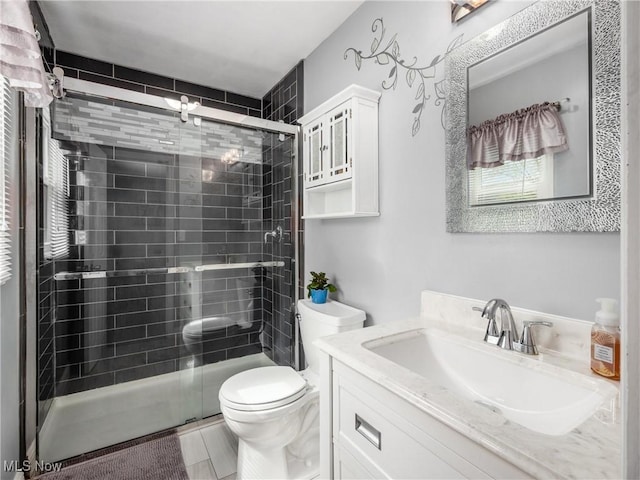 full bath featuring vanity, a shower stall, and toilet