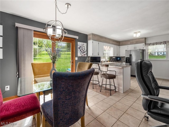 dining space with an inviting chandelier, plenty of natural light, and light tile patterned flooring