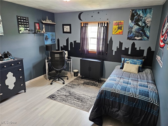 bedroom featuring baseboards and wood finished floors