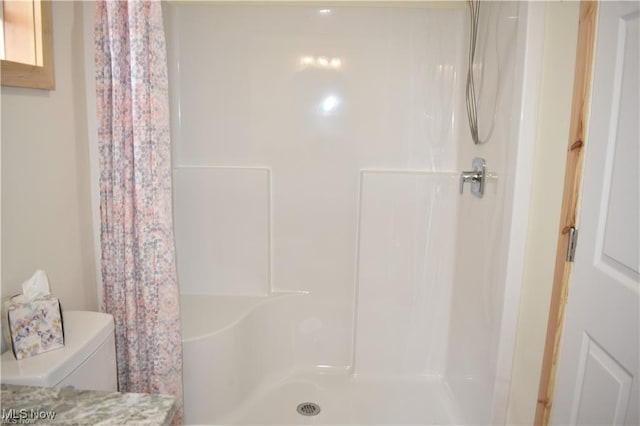 bathroom with toilet and a shower with curtain