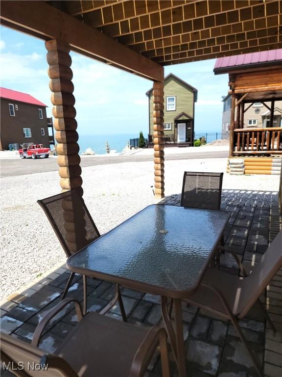 view of patio with a water view and outdoor dining space