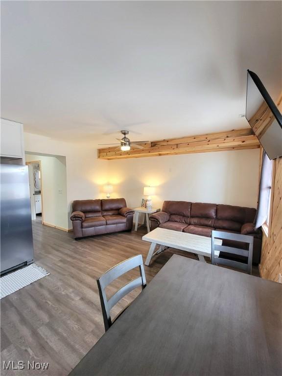 living area with a ceiling fan and wood finished floors
