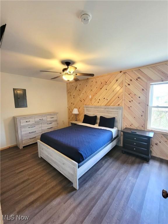 bedroom with dark wood-style flooring, ceiling fan, baseboards, and electric panel