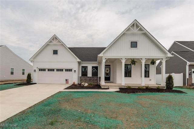 modern inspired farmhouse featuring a porch, a front lawn, board and batten siding, and concrete driveway