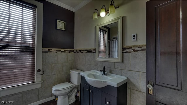 bathroom with vanity, ornamental molding, toilet, and tile walls