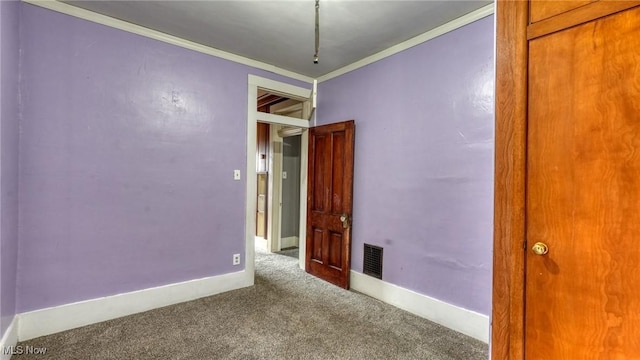 unfurnished room featuring baseboards, ornamental molding, carpet, and visible vents