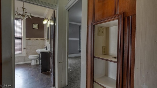 bathroom with toilet, ornamental molding, a healthy amount of sunlight, and vanity