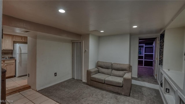 unfurnished living room featuring visible vents, recessed lighting, light tile patterned floors, and light colored carpet