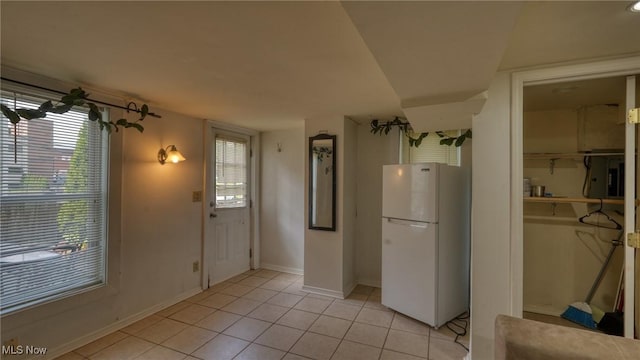 foyer entrance featuring baseboards and light tile patterned floors