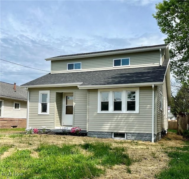 rear view of property featuring fence
