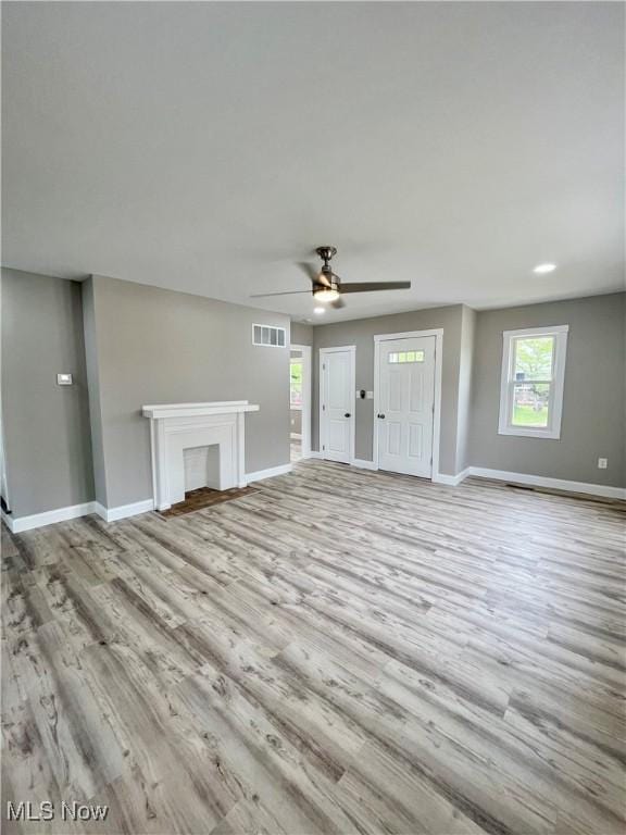 unfurnished living room featuring ceiling fan, baseboards, visible vents, and wood finished floors